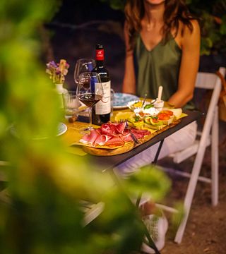 Weinprobe bei Sonnenuntergang zwischen den Weinbergreihen